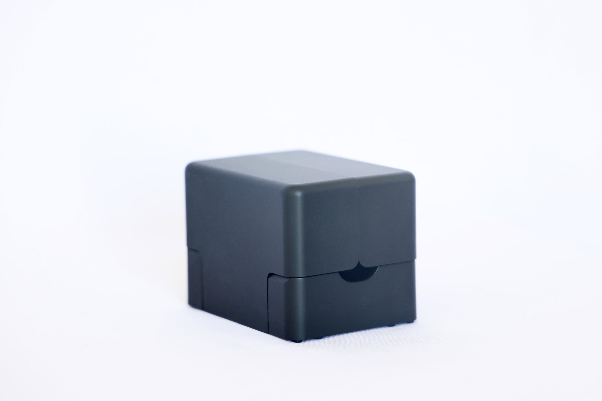 Closed matte black Lotus card shuffler, a compact rounded cube